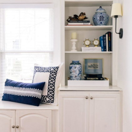 Books and accessories on a built-in bookshelf in a living room