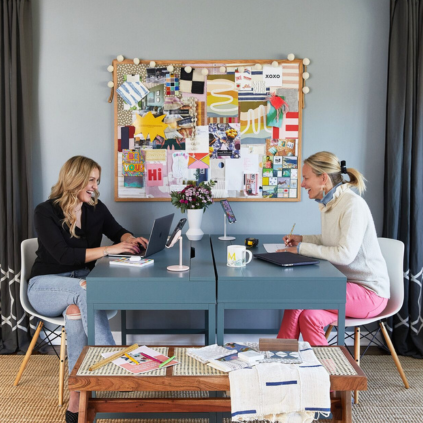 Melissa Mahoney from MMDH Studio sitting at her desk in front of a mood board in her office.