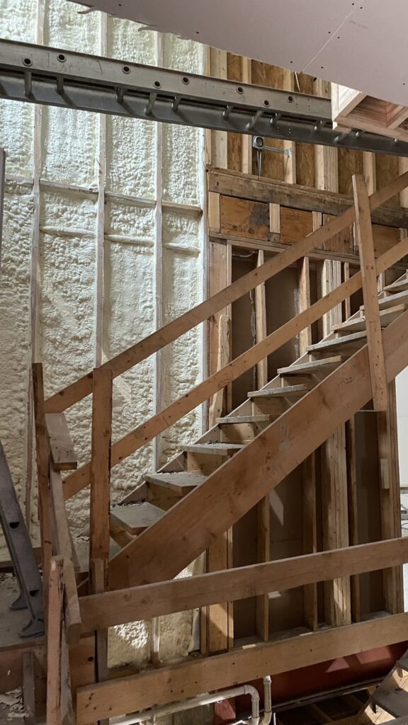 Initial phase of foyer transformation in a new construction house, showing the original empty state before any decor or layout changes.