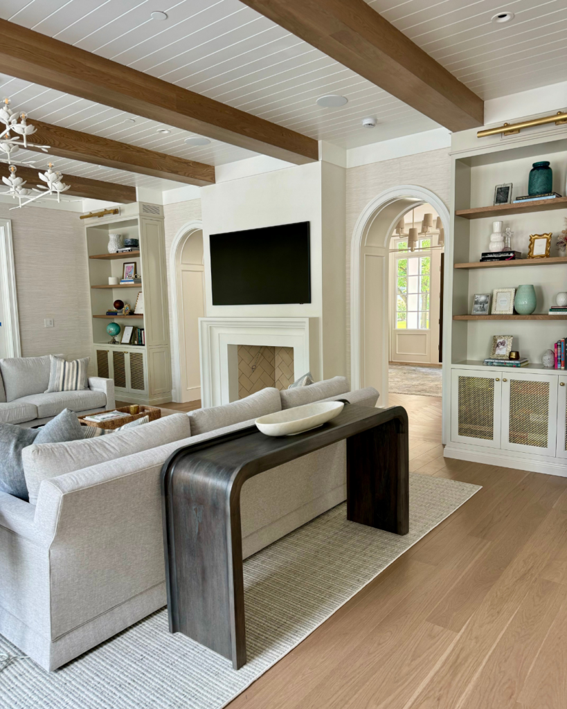 Final phase of new construction light and airy living room design, featuring a plaster fireplace, modern furniture, stylish decorative accents, and a cozy ambiance.