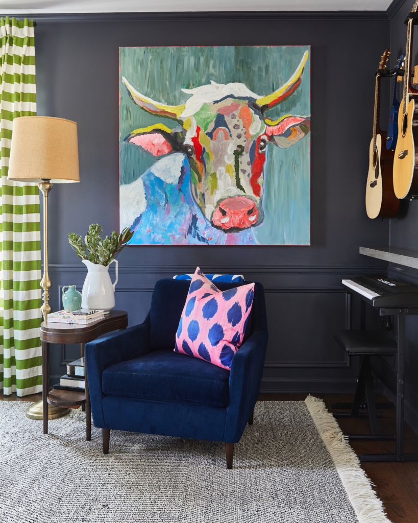 Sitting area with a chair and vibrant art and decor on a dark navy wall, part of a stylish home refresh project.