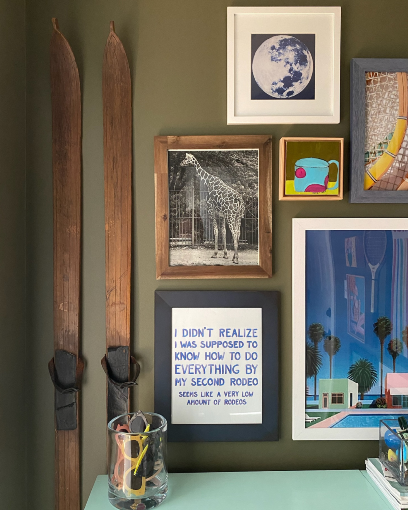 Vibrant gallery wall with artwork on an olive green painted wall, showcasing a home refresh project.