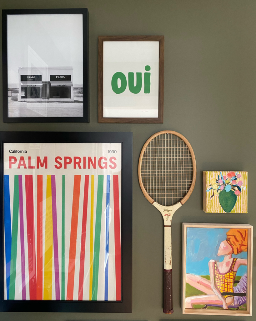 Different angle of vibrant gallery wall with artwork on an olive green painted wall, part of a home refresh project.