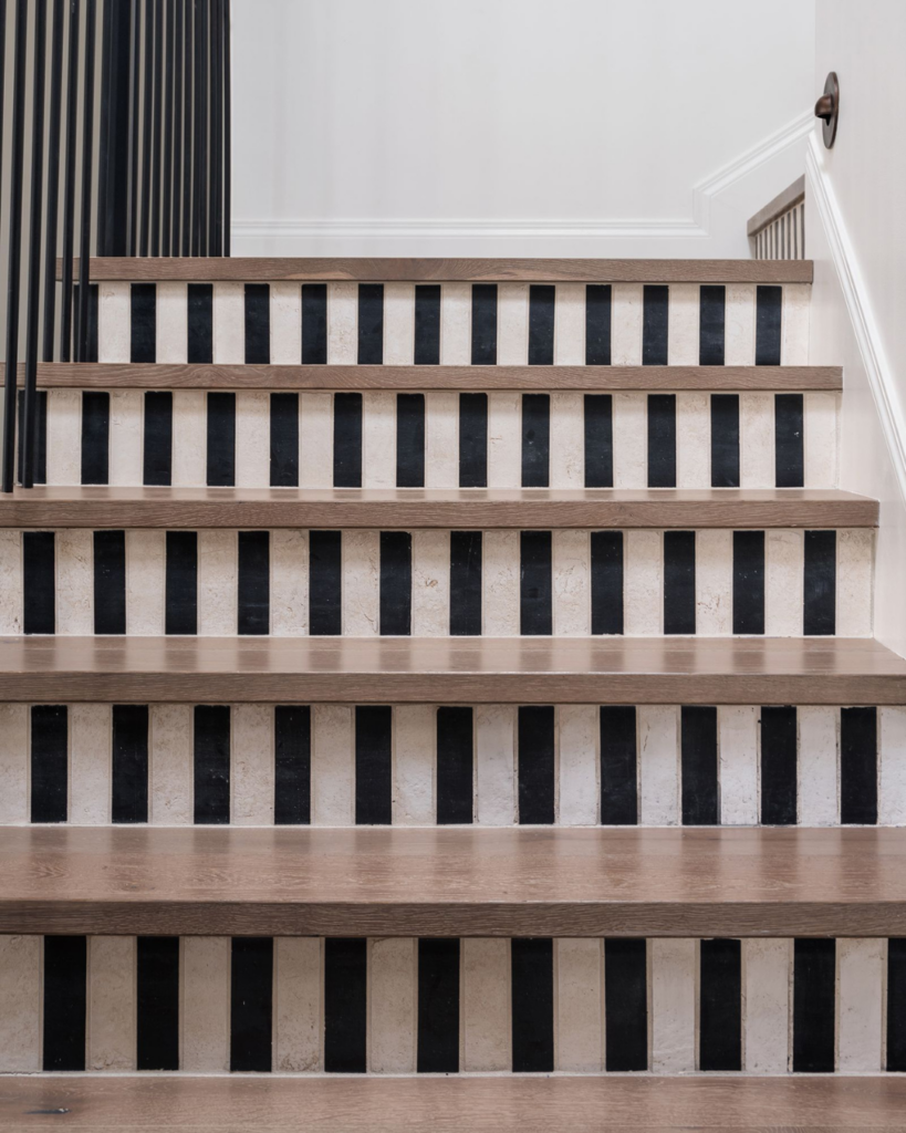 Close-up of staircase with black and white striped painted risers and wood steps, featured in MMDH HQ home project updates