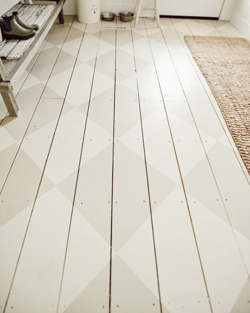 Close-up of wood floor painted with a light white checkerboard design, part of MMDH HQ home project updates.