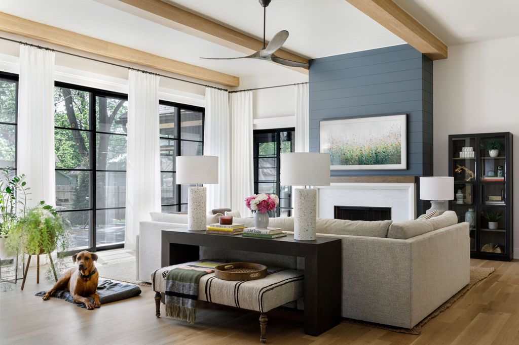 A light and airy transitional living room featuring a fireplace painted in Benjamin Moore Blue Note 2129-30, showcasing the best interior paint colors for 2024.